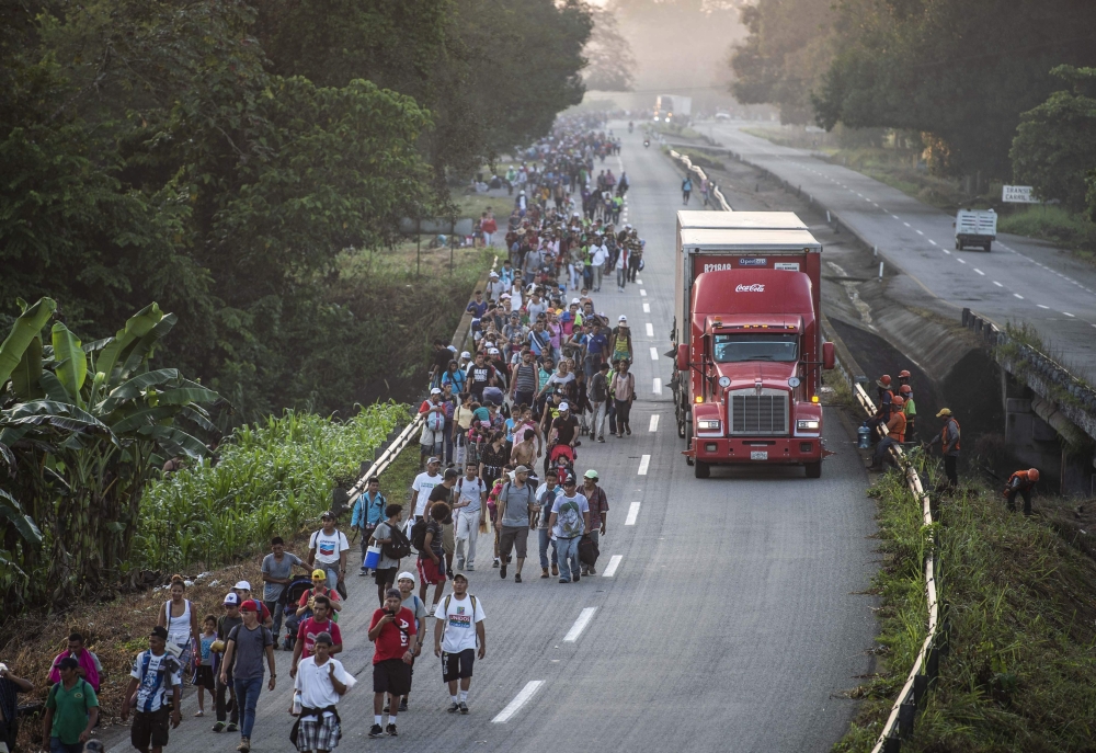 Honduran migrants taking part in a caravan heading to the US, walk alongside the road in Huixtla, Chiapas state, Mexico, on October 24, 2018.   AFP / PEDRO PARDO