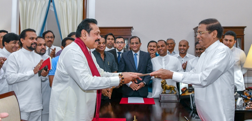 Sri Lanka's former President Mahinda Rajapaksa (Front-L) is sworn in as the new Prime Minister before President Maithripala Sirisena in Colombo, Sri Lanka October 26, 2018. (Sri Lanka's President's Office/Handout via REUTERS)