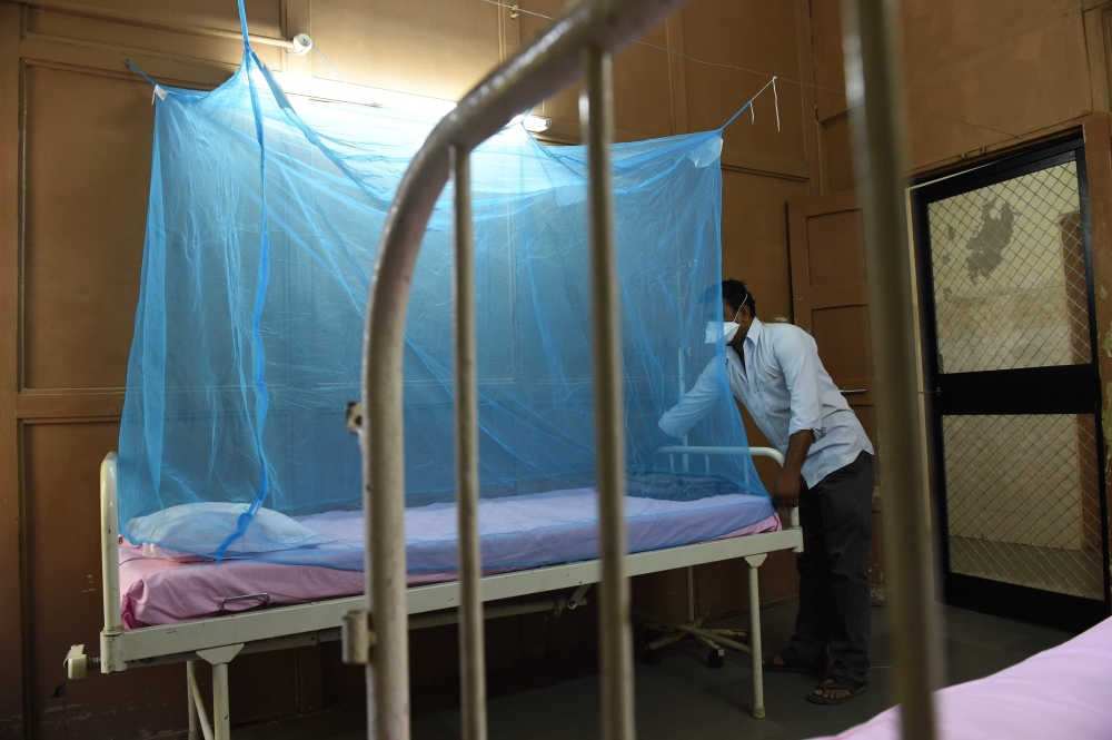 An Indian attendant places a mosquito net to a bed at an isolation ward for Zika Virus patients at Ahmedabad Municipal Corporation-run Vadilal Sarabhai (VS) Hospital in Ahmedabad on October 27, 2018.  AFP / SAM PANTHAKY
