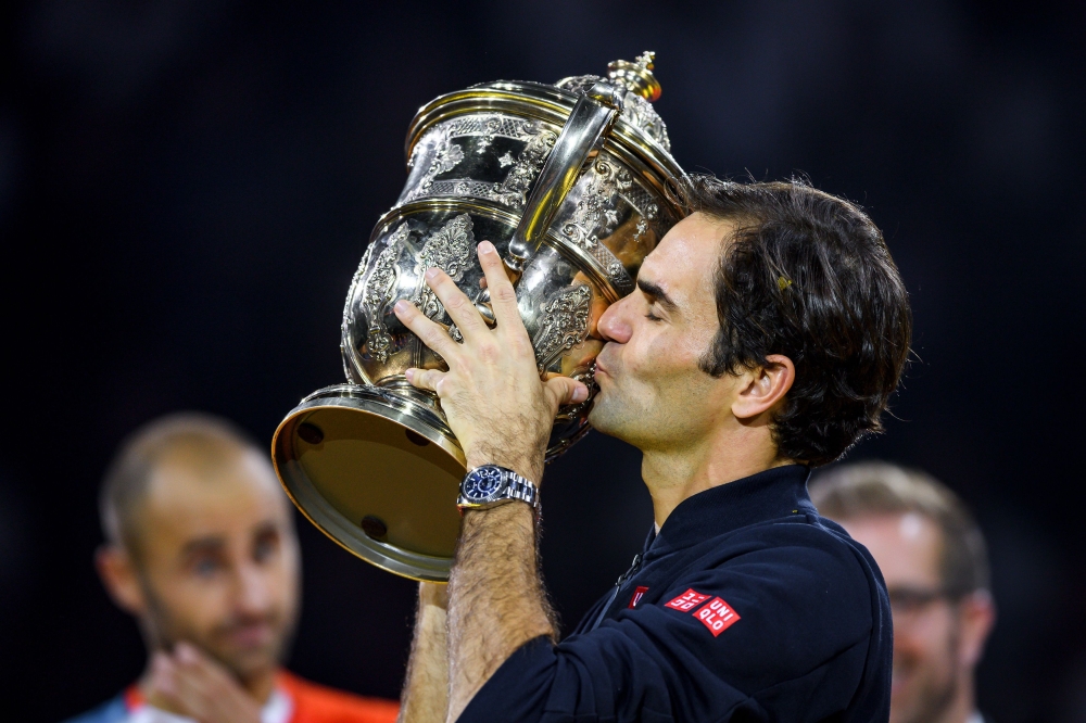 Switzerland's Roger Federer kisses the trophy after his victory against Romania's Marius Copil during their final match at the Swiss Indoors ATP 500 tennis tournament on October 28, 2018 in Basel. - / AFP / Fabrice COFFRINI