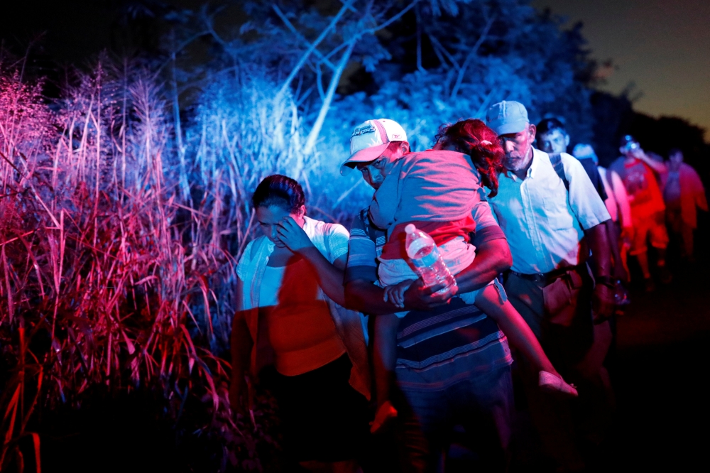 Migrants, part of a caravan traveling to the U.S., walk along the road to Huixtla, near Tapachula, Mexico, October 31, 2018. REUTERS/Carlos Garcia Rawlins 