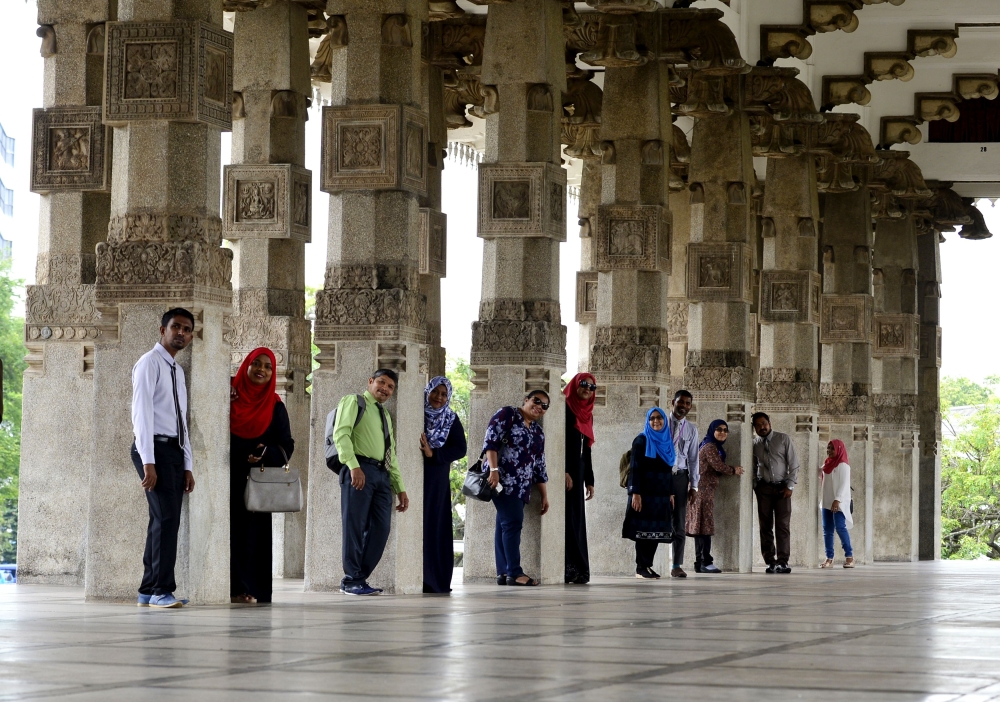Foreign tourist pose for photographers at Sri Lanka's Independence Memorial Hall, which was built to commemorate the country's independence from British rule, in Colombo on November 5, 2018. / AFP / LAKRUWAN WANNIARACHCHI