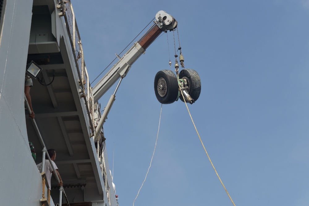 The wheels of the Lion Air flight JT 610 is lifted into the Indonesia's KRI Banda Aceh warship during a salvage operation in the Java Sea on November 2, 2018.  / AFP / ADEK BERRY 