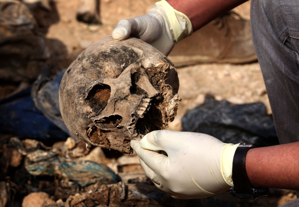 REPRESENTATIVE IMAGE: Members of the Yazidi minority search for clues, that might lead them to missing relatives in the remains of people killed by the Islamic State group a day after Kurdish forces discovered a mass grave near the Iraqi village of Sinuni