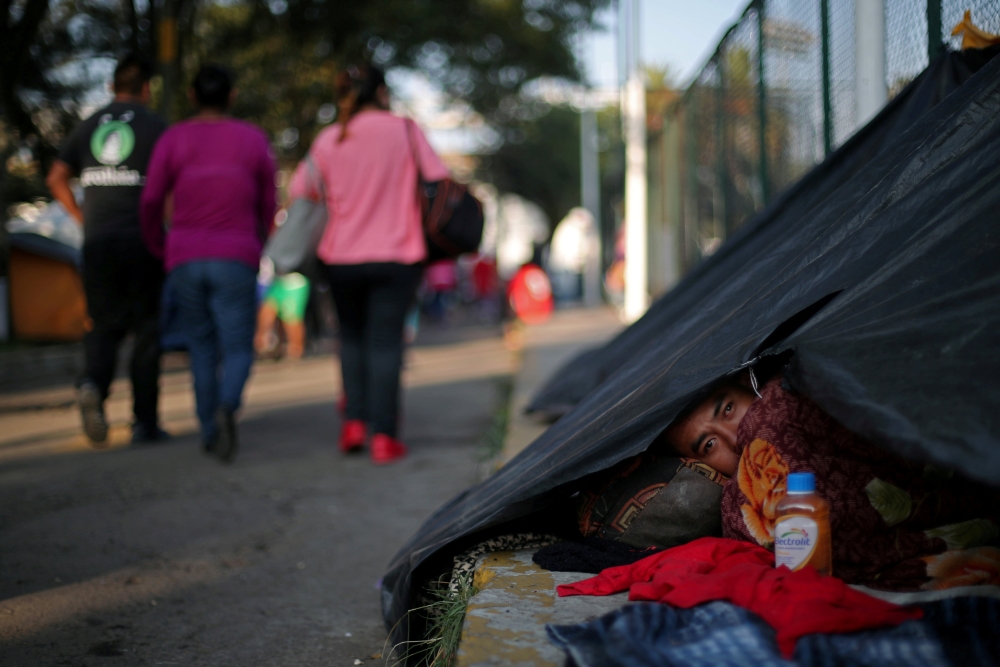 A migrant, part of a caravan of thousands travelling from Central America en route to the United States, rests in a makeshift camp in Mexico City, Mexico, November 8, 2018. REUTERS/Hannah McKay 