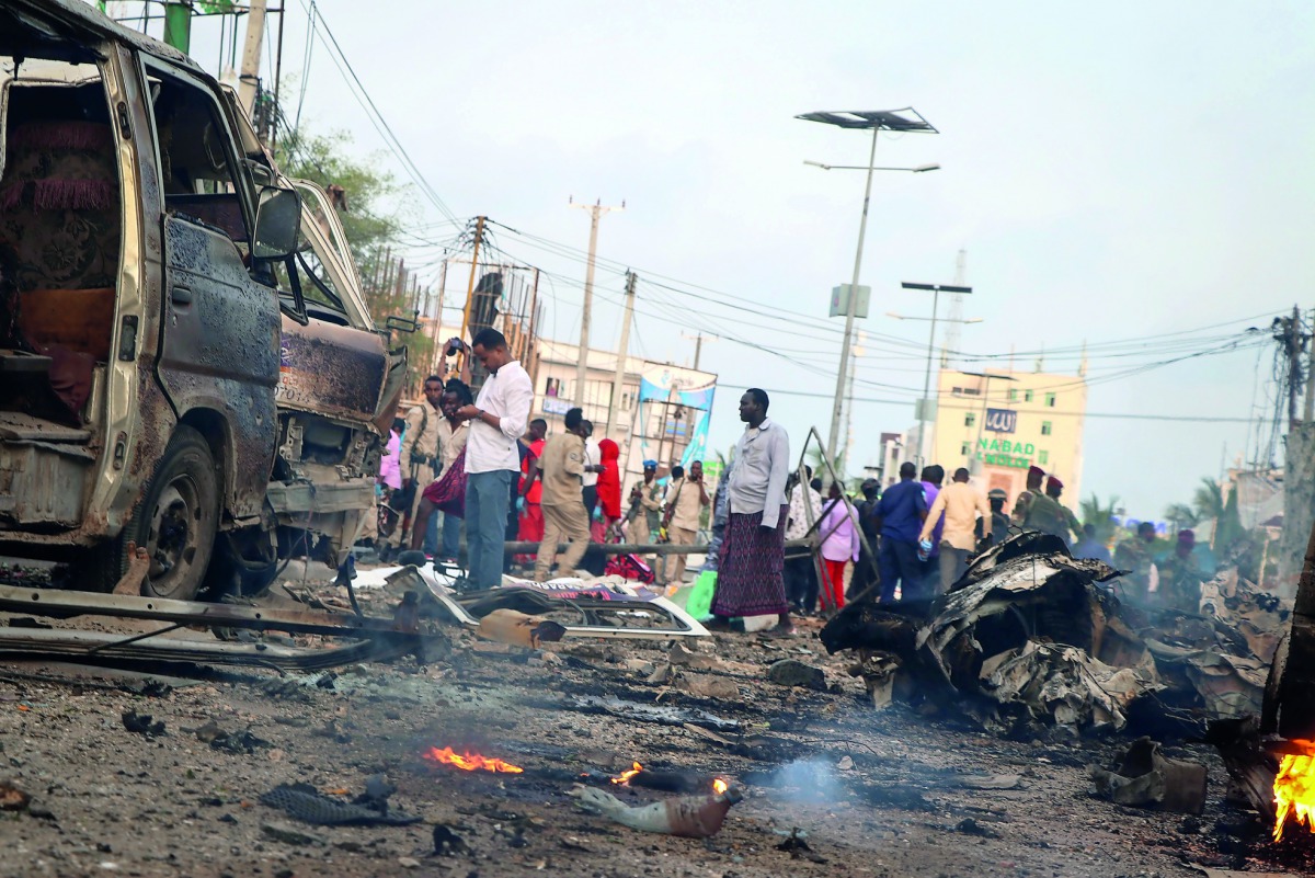  People gather at the scene of twin car bombs that exploded within moments of each other in the Somali capital Mogadishu on November 9, 2018.  AFP / Abdirazak Hussein Farah