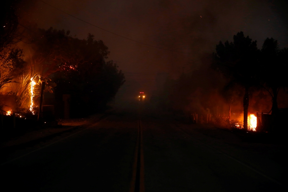 The Woolsey Fire burns in Malibu, California, U.S. November 9, 2018. The fire destroyed dozens of structures, forced thousands of evacuations and closed a major freeway. REUTERS/Eric Thayer