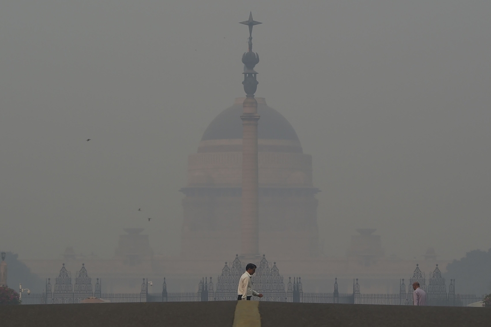 A pedestrian crosses a road near the Indian President's house amid heavy smog in New Delhi on November 8, 2018. AFP / Money Sharma 