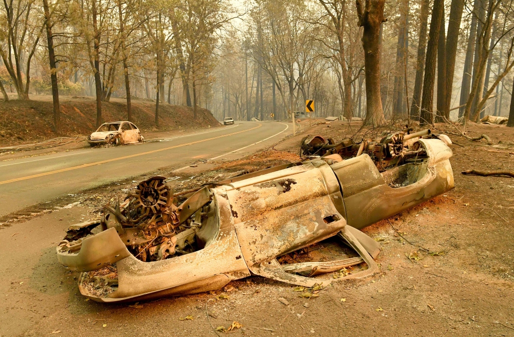 Burned cars litter a road during the Camp fire in Paradise, California on November 12, 2018.  AFP / Josh Edelson