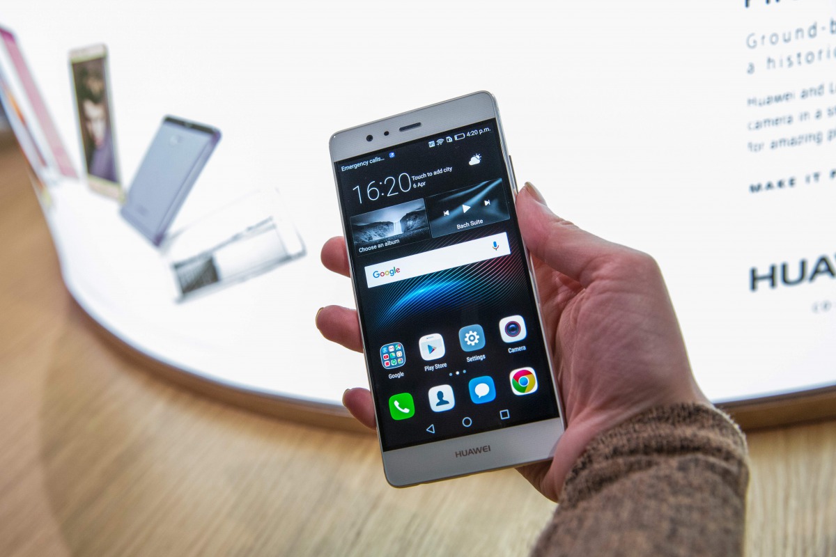 A woman poses holding the new P9 smartphone by Chinese tech company Huawei during the launch at Battersea Evolution in London on April 6, 2016. AFP/Jack Taylor