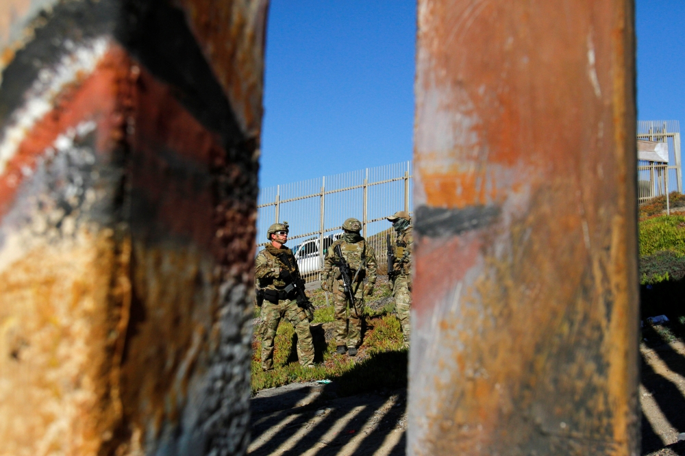 Agents with the U.S. Border Patrol Tactical Unit (BORTAC) stand guard behind the border fence between Mexico and the United States, as seen from Tijuana, Mexico November 14, 2018. REUTERS/Jorge Duenes