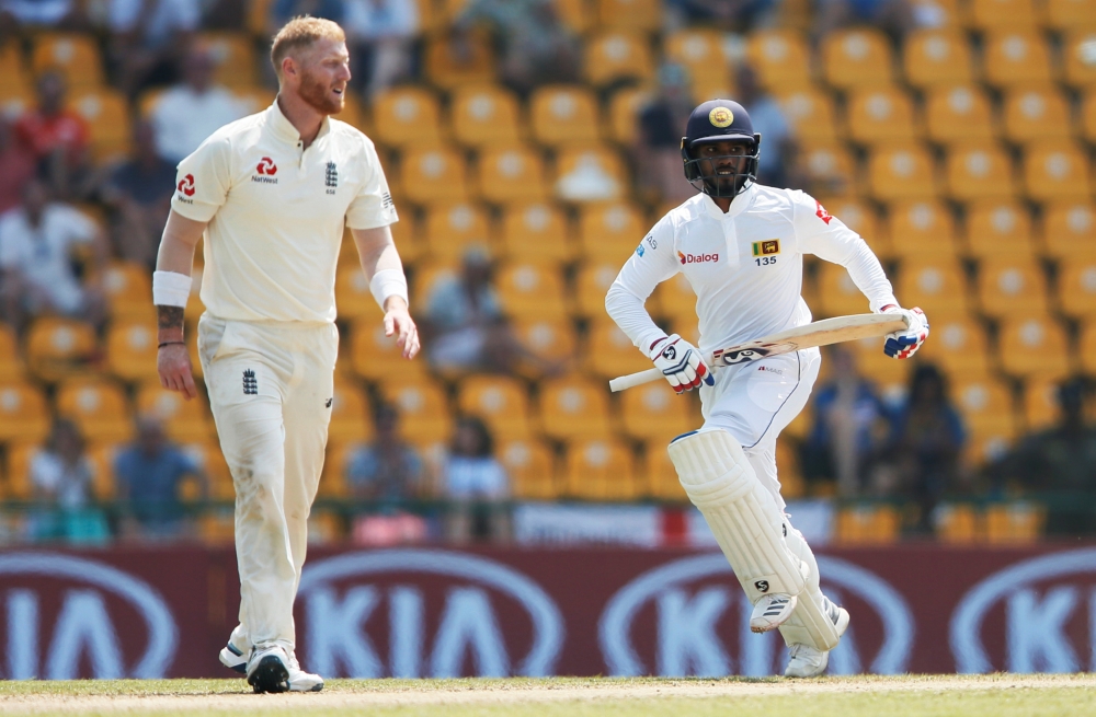 Sri Lanka's Dhananjaya de Silva (R) runs between wickets next to England's Ben Stokes. REUTERS/Dinuka Liyanawatte