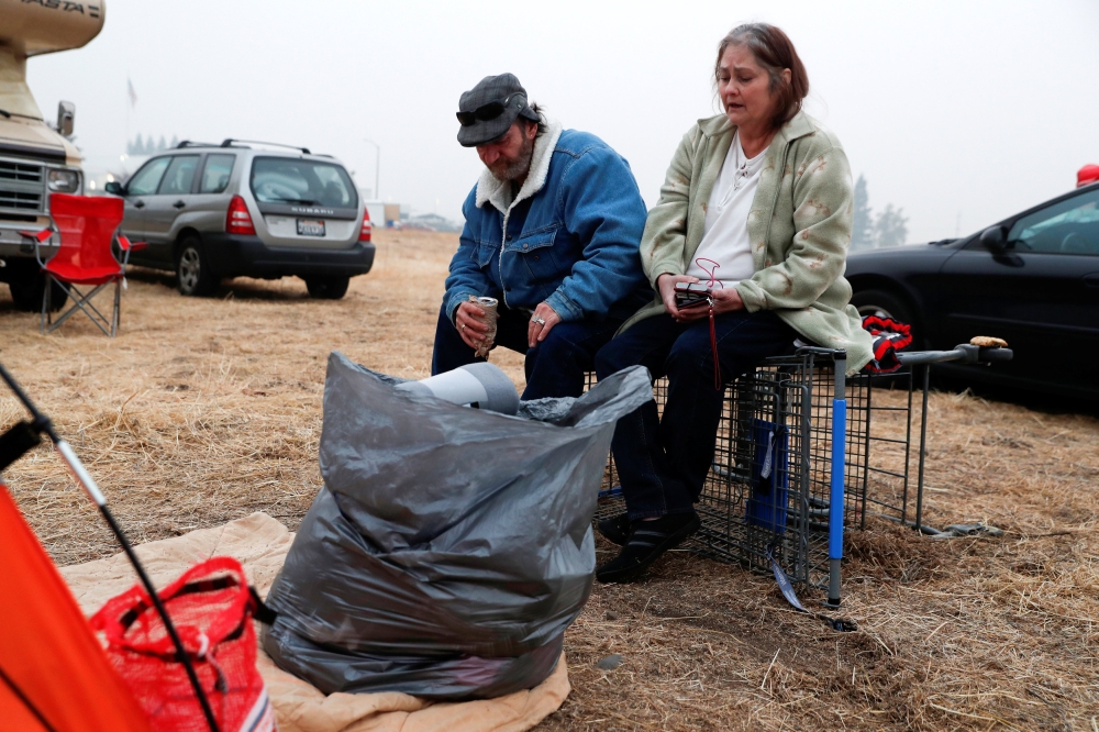 Anna and William Goodnight, of Paradise, sit outside their tent at a makeshift evacuation center for people displaced by the Camp Fire in Chico, California, November 15, 2018. Reuters/Terray Sylvester  
