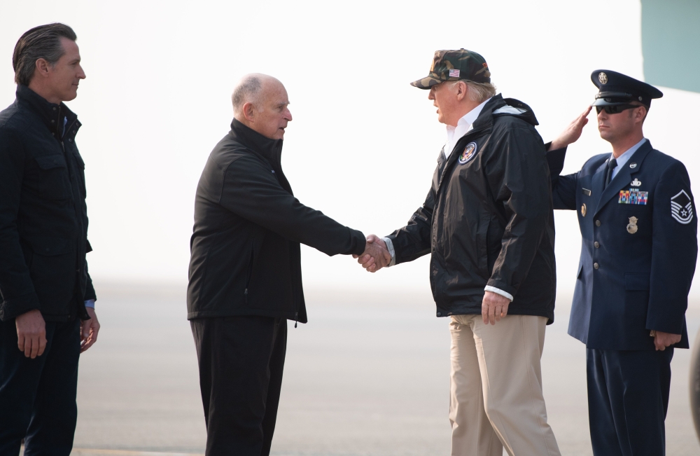 US President Donald Trump greets California Governor Jerry Brown and Governor-elect Gavin Newsom (L) as he arrivesl at Beale Air Force Base in California, November 17, 2018. Trump is in California to view fire damage. / AFP / SAUL LOEB
