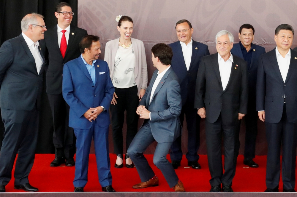 Canada's Prime Minister Justin Trudeau shares a joke about his height with New Zealand's Prime Minister Jacinda Ardern during a family photo at the APEC Summit in Port Moresby, Papua New Guinea November 18, 2018. REUTERS/David Gray 