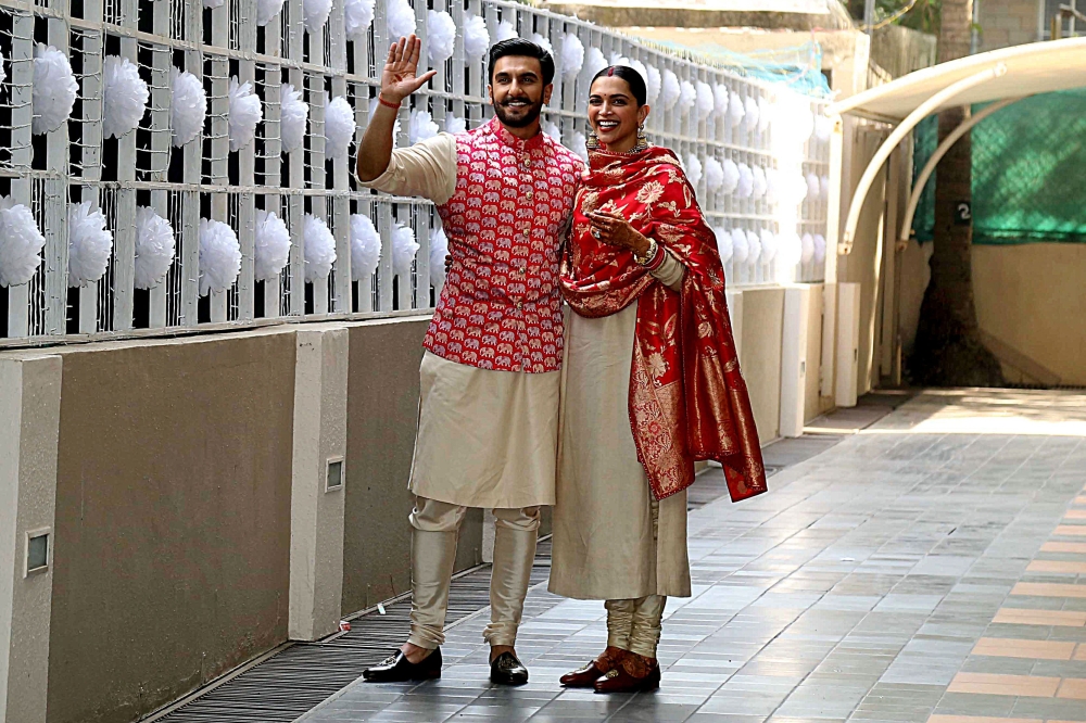Indian Bollywood actors and recently-wedded couple Ranveer Singh (L) and Deepika Padukone pose after arriving at their residence in Mumbai on November 18, 2018, following their return from their nuptials at Italy's Lake Como. AFP 