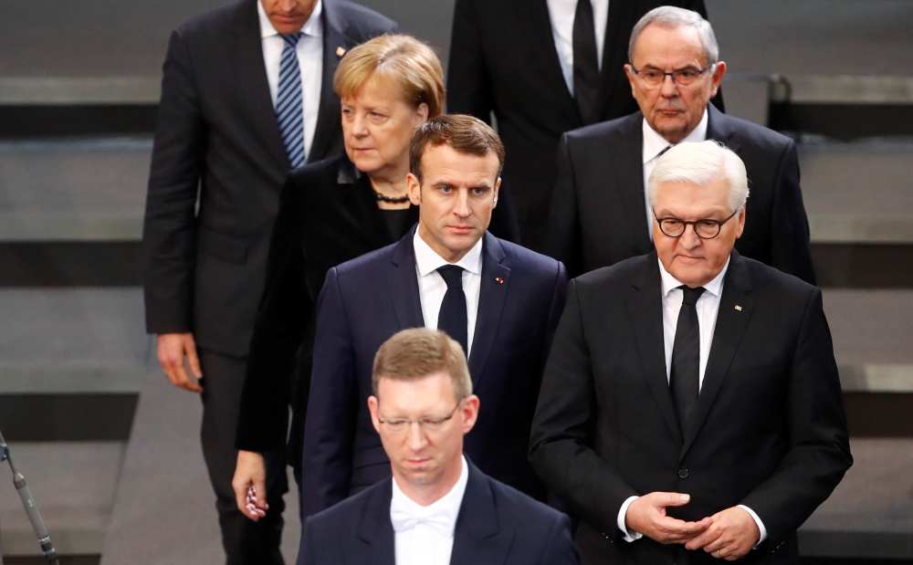 French President Emmanuel Macron, German President Frank-Walter Steinmeier and German Chancellor Angela Merkel arrive to attend a ceremony at the lower house of parliament Bundestag in the Reichstag building in Berlin to mark National Mourning Day, German