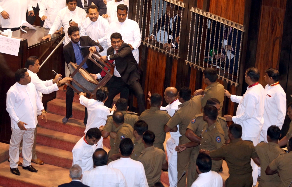 Parliament member Johnston Fernando who is backing newly appointed Prime Minister Mahinda Rajapaksa throws a chair at police who are there to protect parliament speaker Karu Jayasuriya (not pictured) during a parliament session in Colombo, Sri Lanka Novem