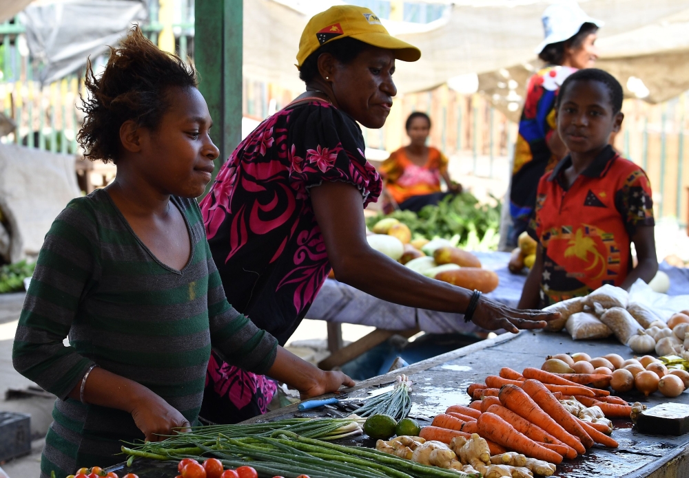 Vendors sell vegetables at a women's only makeshift market on the outskirts of Port Moresby on November 19, 2018, one day after the Asia-Pacific Economic Cooperation (APEC) Summit. AFP / SAEED KHAN