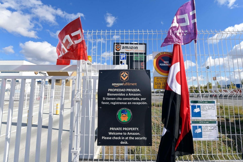 Union flags are pictured outside Amazon facilities in San Fernando de Henares, the biggest in Spain, during a strike on November 23, 2018.  AFP / Oscar Del Pozo 