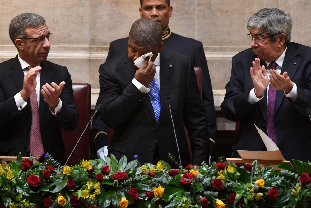 Angolan president Joao Lourenco Angolan president Joao Lourenco (C) wipes his face after delivering a speech at the parliament in Lisbon on November 22, 2018. AFP / Francisco Leong  