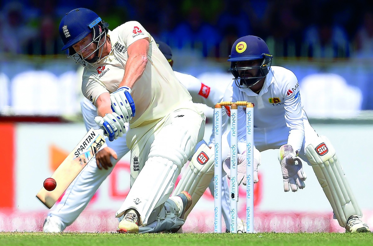 England's Jonny Bairstow (L) plays a shot as Sri Lanka's wicketkeeper Niroshan Dickwella (R) looks on during the first day of the third Test match between Sri Lanka and England at the Sinhalese Sports Club (SSC) international cricket stadium in Colombo on