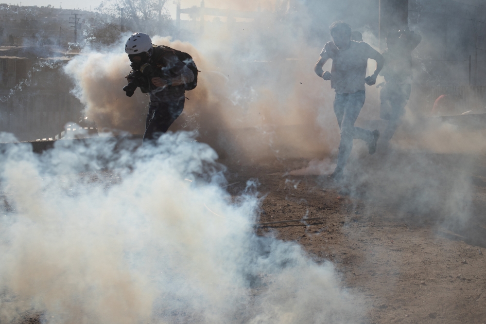 A photojournalist is surrounded in a cloud of tear gas released by U.S. Customs and Border Protection (CBP) after migrants, part of a caravan of thousands from Central America, attempted to illegally cross the border into the United States from Tijuana, M