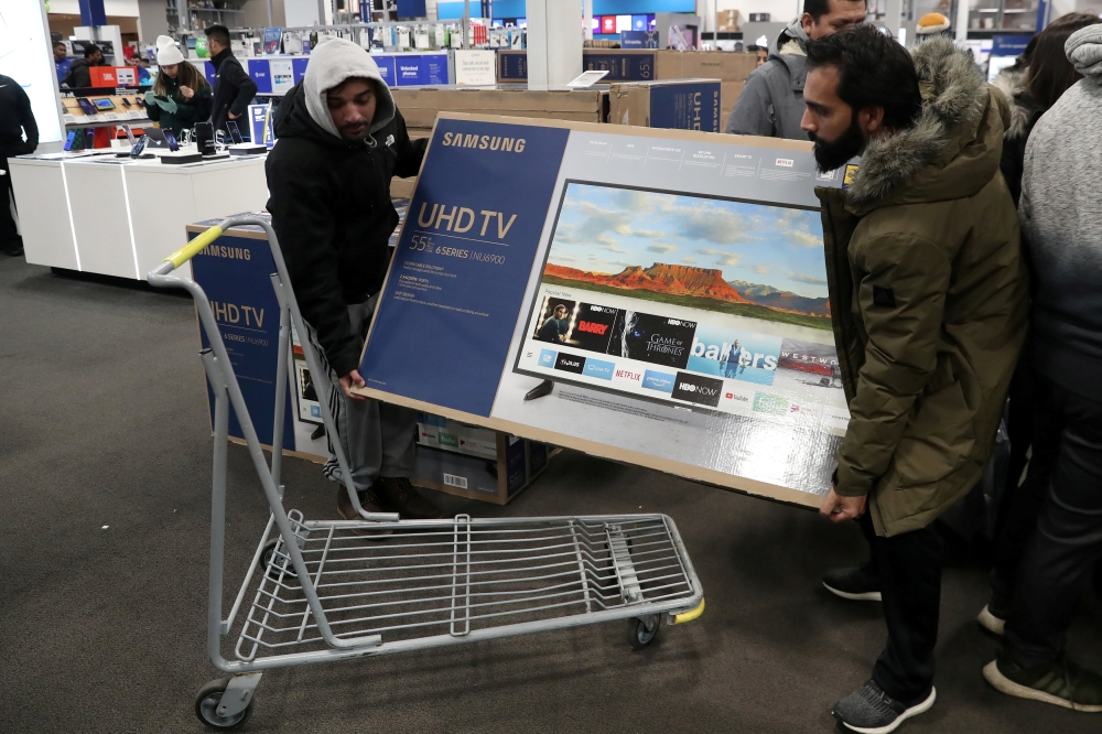 People carry a television inside a Best Buy during a sales event on Thanksgiving day in Westbury, New York, November 22, 2018. Reuters/Shannon Stapleton/