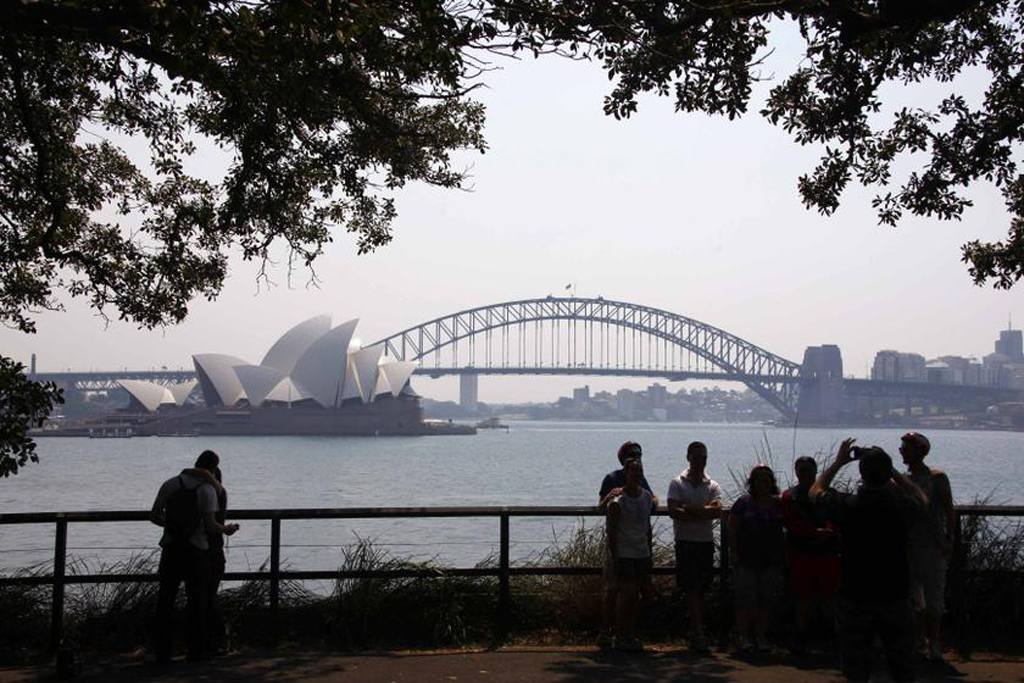 File photo of tourists standing in front of the Sydney Opera House and Harbour Bridge on a hazy day October 21, 2013. — Reuters pic