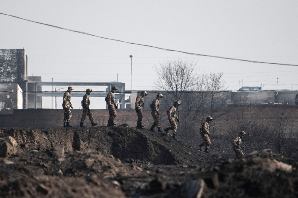 Members of the Chinese military inspect the area after an explosion near a chemical factory in Zhangjiakou, some 200km northwest of Beijing on November 28, 2018. / AFP / FRED DUFOUR