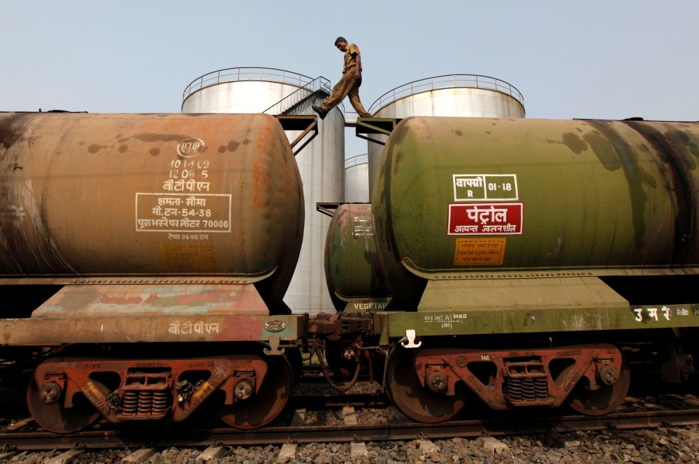 A worker walks atop a tanker wagon to check the freight level at an oil terminal on the outskirts of Kolkata November 27, 2013. REUTERS/Rupak De Chowdhuri/File Photo