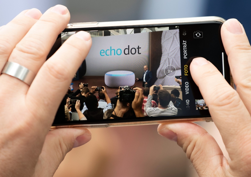 An attendee snaps phone videos of Dave Limp, Amazon's senior vice president for devices and services, as he announces the new Echo Dot at The Spheres in Seattle on September 20, 2018. AFP / Grant Hindsley 