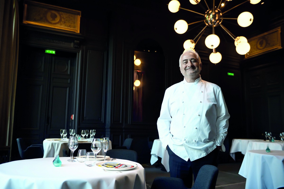 French chef Guy Savoy poses in the dining room of his Michelin three-starred restaurant 