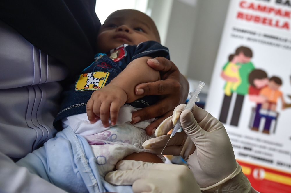 (FILES) In this file photo taken on September 19, 2018 a medical worker injects a baby with a measles-rubella (MR) vaccine at a health station in Banda Aceh in Aceh province. AFP / CHAIDEER MAHYUDDIN