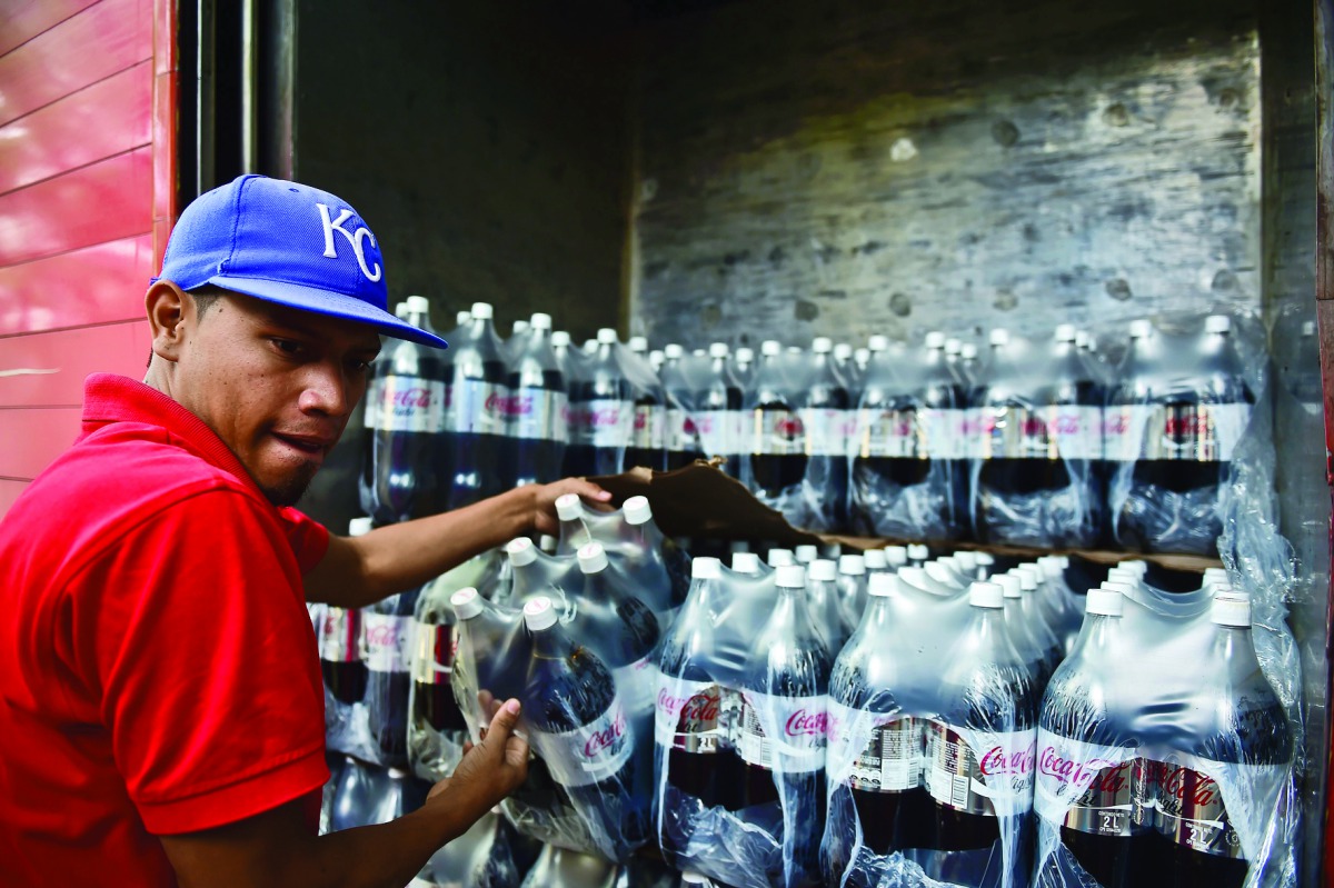 A man unloads bottles of Coca Cola from a truck. AFP/Ronaldo Schemidt
