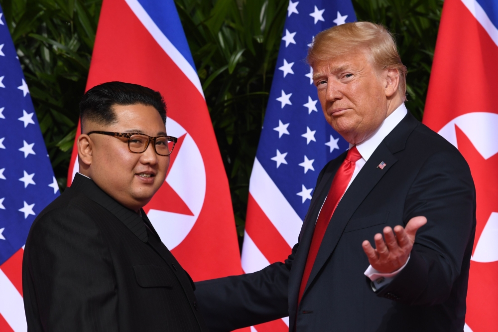 File photo of US President Donald Trump (R) gestures as he meets with North Korea's leader Kim Jong Un (L) at the start of their historic US-North Korea summit, at the Capella Hotel on Sentosa island in Singapore on June 12, 2018.  / AFP / SAUL LOEB
