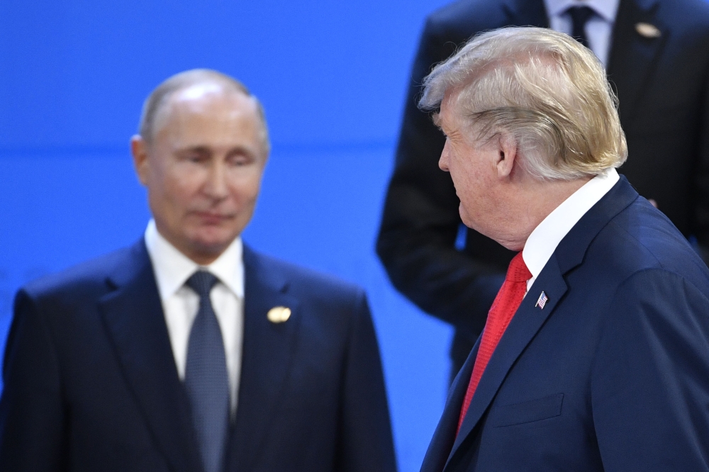 US President Donald Trump (R) looks at Russia's President Vladimir Putin as they take their places for a family photo, during the G20 Leaders' Summit in Buenos Aires, on November 30, 2018. AFP / Alexander NEMENOV