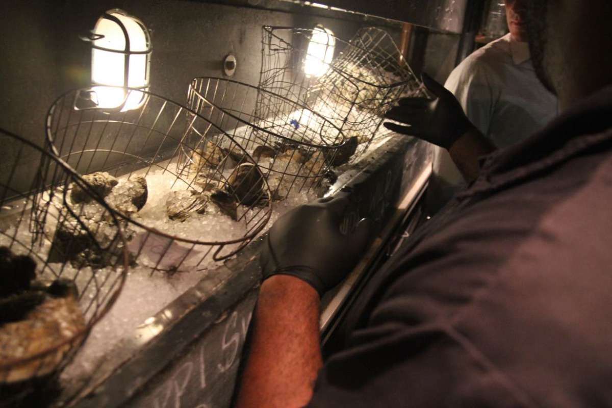 A restaurant employee chucks an oyster at Seaworthy, a seafood restaurant in New Orleans, Louisiana that recycles the mollusk's shells as part of a community project to build oyster-shell made breakwaters. November 16, 2018. TRF/Sebastien Malo