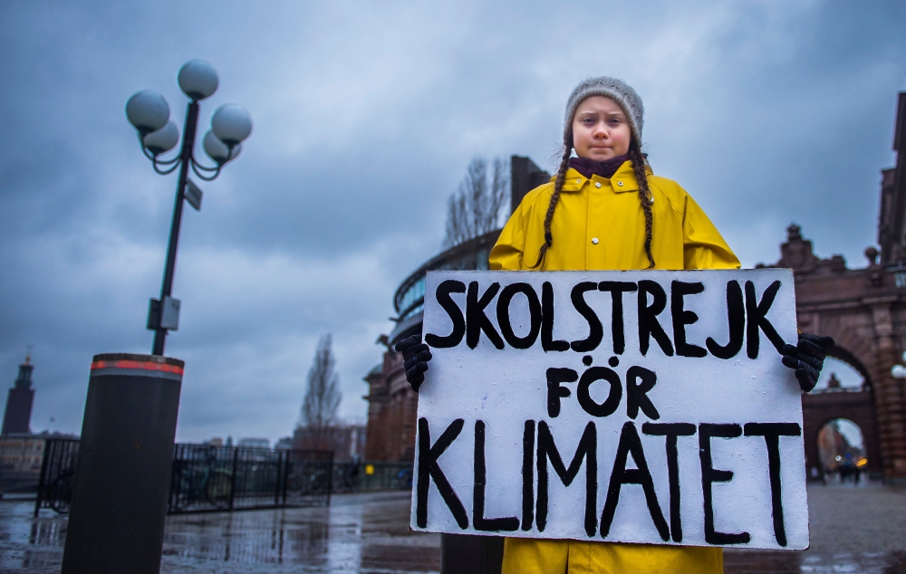 15-year-old Swedish girl Greta Thunberg holds a placard reading 
