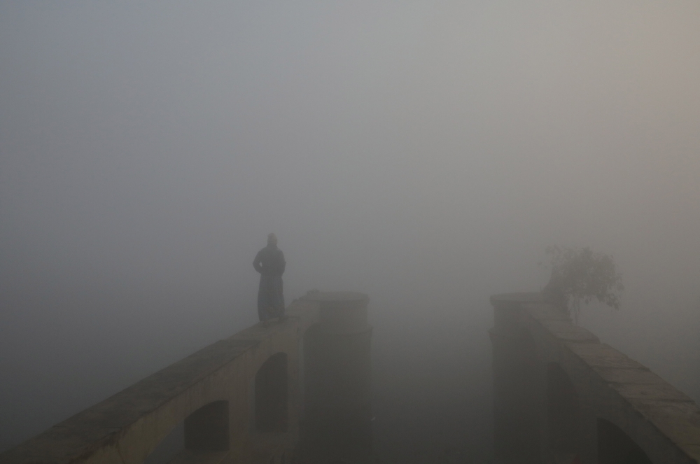 A man walks on the banks of the Yamuna River during a foggy morning in the old quarters of Delhi, India, December 4, 2018. REUTERS/Anushree Fadnavis