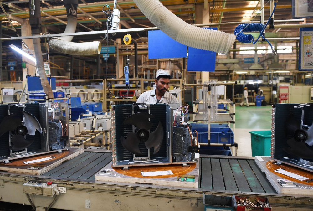 This photograph taken on November 23, 2018 shows an Indian worker on the production line in the Daikin air conditioning plant in Neemrana, about 120km southwest of the Indian capital New Delhi. AFP / Money SHARMA 