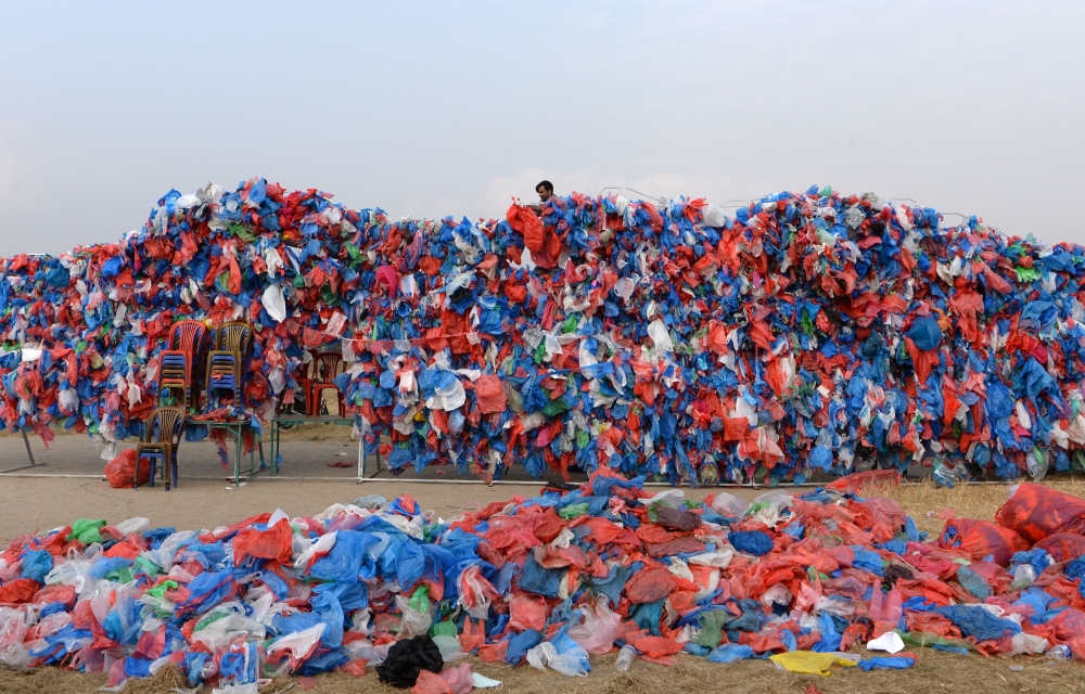 A Nepali volunteer ties up recycled plastic bags to make a sculpture shaped like the Dead Sea to set a new world record for the largest sculpture made out of recycled plastic bags, in Kathmandu on December 5, 2018.  AFP / PRAKASH MATHEMA
