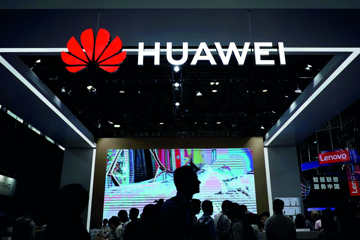 People walk past a sign board of Huawei at CES (Consumer Electronics Show) Asia 2018 in Shanghai, China June 14, 2018. Reuters/Aly Song