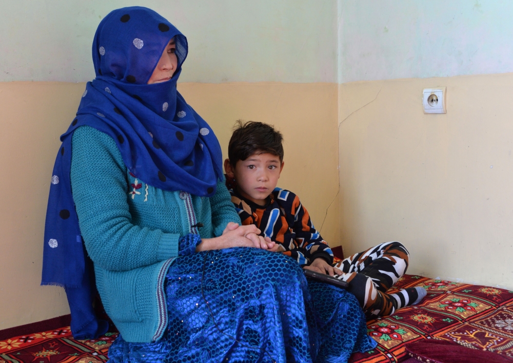 This picture taken on December 3, 2018 shows Murtaza Ahmadi, a supporter of Argentine footballer Lionel Messi, sitting next to his mother inside their home in Kabul. AFP / NOORULLAH SHIRZADA /