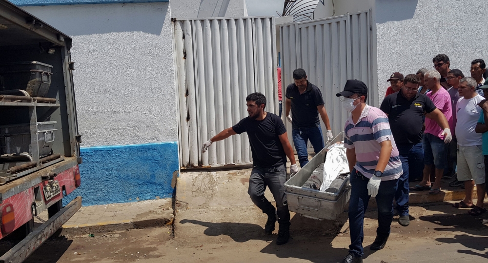 Forensic experts carry a corpse to be transported to the morgue after an attempted bank robbery in Milagres, Ceara state, Brazil on December 07, 2018. AFP / Agencia Miseria / Normando Soracles 