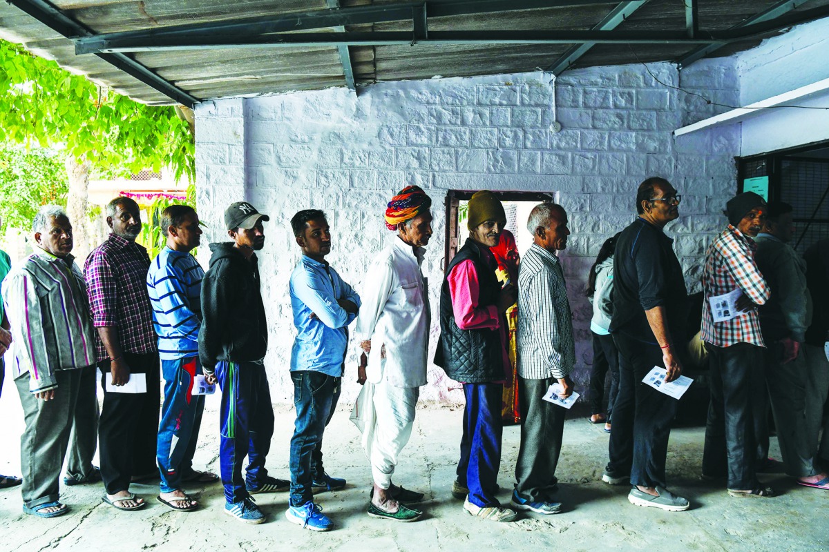 Indian men stand in queue to cast their vote at a local polling station during Rajasthan's Legislative Assembly election, in Jodhpur on December 7, 2018. AFP / Chandan Khanna
