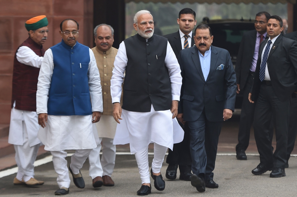 Indian Prime Minister Narendra Modi (C) walks upon his arrival for the winter session of parliament in New Delhi on December 11, 2018. / AFP / Money SHARMA
 