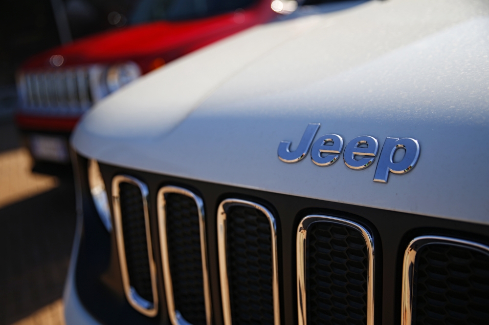 FILE PHOTO: In this file photo taken on August 21, 2017 a car dealer in Turin shows the logos of Jeep, brands of Fiat Chrysler Automobiles (FCA).  AFP / Marco BERTORELLO
