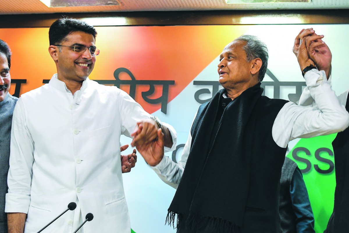 Newly-appointed Rajasthan chief minister Ashok Gehlot (R) and his newly-appointed deputy Sachin Pilot gesture as they hold hands during a press conference at the All India Congress Committee offices in New Delhi on December 14, 2018. AFP / Chandan Khanna