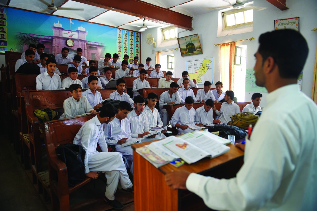Children attend a class at a government school in Peshawar on September 17, 2018. AFP/Farooq Naeem